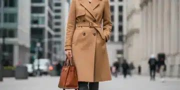 Woman in classic trench coat and leather bag, representing smart wardrobe investments for longevity.